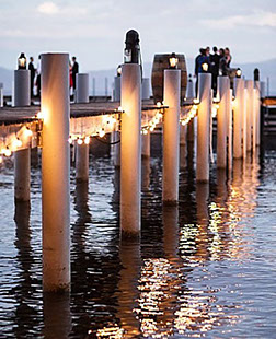 String lights on a pier for a wedding party.